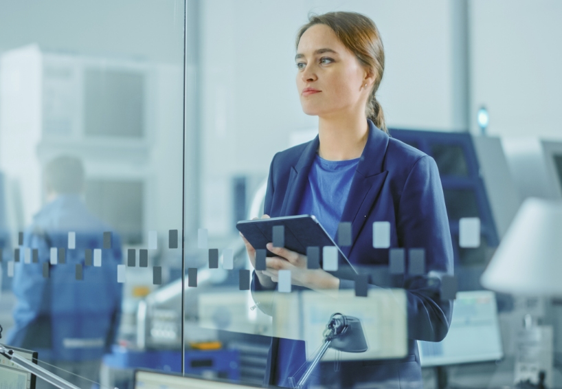 Woman in a laboratory wearing a blue coat and holding a tablet computer