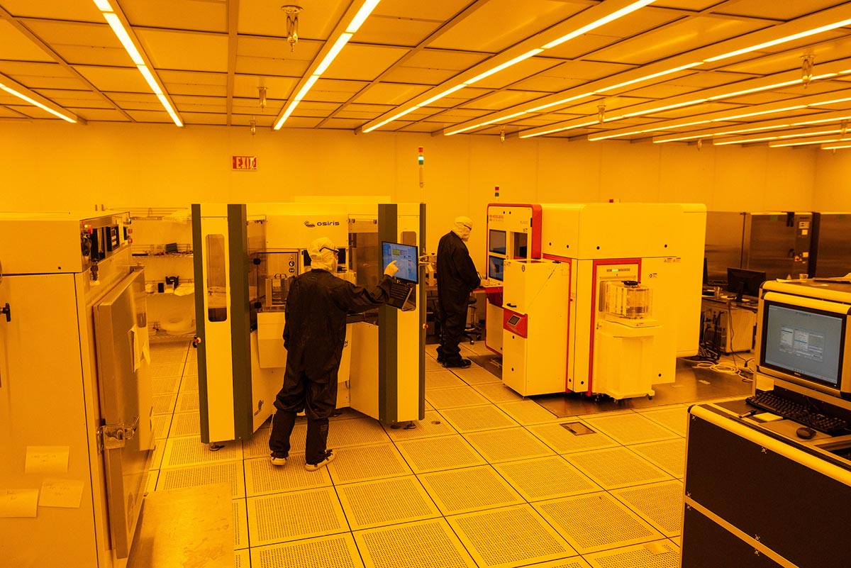 Inside the MTW fab facility where workers stand at large machines.